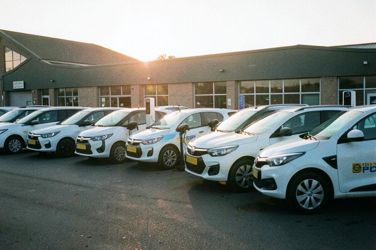 Line of electric company cars parked at a UK depot